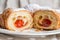 Close up, macro. French croissants. One of the croissants is cut in half, inside an appetizing juicy strawberry filling