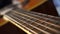 Close up macro on guitar strings or chords with very slow movement or panning. Musical instrument. Music and sound concept