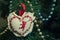 Close up, macro. Heart shaped Christmas decoration. Festive garlands on the background