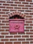 Close up of a mailbox cemented into a red brick wall in downtown Georgetown