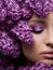Close-up make up in pink and purple shades and with flowers around face. Inspiration of spring. Beauty and cosmetics