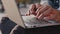 Close up male african american worker user hands fingers quickly typing on laptop sit outdoors city, ethnic businessman