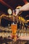 Close up of a male bartender dispensing draught beer in a pub holding large glass tankard under a spigot attachment on a