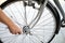 A close-up of a male bicycle mechanic`s hand  uses a tool to adjust and repair the bicycle.