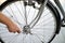 A close-up of a male bicycle mechanic`s hand  uses a tool to adjust and repair the bicycle.