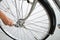 A close-up of a male bicycle mechanic`s hand  uses a wrench to adjust and repair the bicycle.