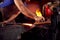 Close Up Of Male Blacksmith Using Wire Brush On Metalwork Resting On Anvil With Sparks