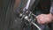 Close-up of a male brewer opening a tap for dispensing beer from a beer tank to a keg