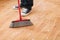 Close up of male brooming wooden floor