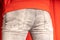 Close up of male buttocks in grey jeans. Rear view on buttocks of unrecognizable man.