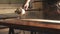 Close-up of a male carpenter`s hands spraying varnish or primer using compressed air on a wooden tabletop. Furniture manufacture