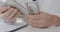 Close-up of male Caucasian hands counting dollars. Unrecognizable man in physician uniform holding pack of money