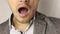 Close-up on male chin with three-day stubble. tired solid man in gray jacket and white dappled shirt yawns. . No face