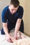 Close-up of male chiropractor hands massaging calves of a small patient. A little boy at the reception of the procedure