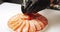 Close up of male cook hands in gloves decorating dish of daikon salad and slices of salmon with red caviar in the kitchen