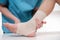 Close-up of male doctor bandaging foot of female patient