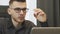 Close up of male face in glasses looking at screen. Confident focused businessman looking at laptop screen. Portrait of man workin