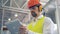 Close up of a male factory worker in protection uniform working with his tablet