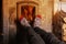 Close up of male feet legs in colored woolen socks are warming near flame, firewood burns in stove, fireplace, cozy winter evening
