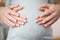 Close Up Of Male And Female Hands Resting On Pregnant Womans Stomach