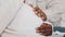 Close-up male and female hands stroking pregnant belly of woman in white clothes, African American unrecognizable couple