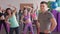 Close-up of male fitness trainer. He looks at a group of girls who train in an aerobic gym