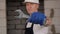 Close-up of a male foreman in blue construction gloves holding a wrench.