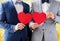 Close up of male gay couple holding red hearts