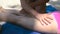 Close-up on male hand applying sun screen creme on a girlfriend`s tanned legs.