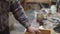 Close up of male hand cleaning a light wooden stand with a rag