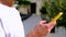 Close-up of male hand hold smartphone, using phone in city, beautiful blurred background, time to chat with friends, apps in