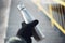 Close-up of male hand holding dressed black glove, holding used reusable steel thermo water bottle on blurred background.