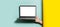 Close-up of male hand holding laptop with mockup between two studio backgrounds of yellow and aqua menthe colors.