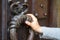 Close-up male hand on a huge antique doorknob ring, selective focus