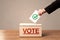 Close up of male hand putting vote into a ballot box