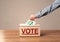 Close up of male hand putting vote into a ballot box