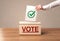 Close up of male hand putting vote into a ballot box