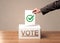 Close up of male hand putting vote into a ballot box