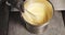 Close up of male hands of cook in gloves whipping cream or sauce with a whisk in the kitchen