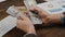 close-up of male hands counting a stack of hundred-dollar US banknotes.