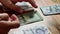 Close-up of male hands counting a stack of hundred-dollar US banknotes. A businessman is counting cash. The concept of