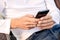 Close up of male hands holding black smartphone. An unundentified person texting online