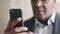 Close-up male hands holding phone, african mature aged business man afro employer uses modern smartphone to order