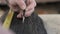 Close-up of male hands making markings on a burnt wooden board with a simple pencil and tape measure. carpenter marks a wooden