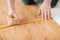 Close up of male hands measuring wood flooring