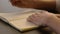 Close-up of male hands and notebook of unidentified young writer.