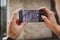 Close-up male hands of a photographer hold a smartphone horizontally and take pictures of CCTV cameras on the corner of