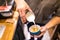 Close up of male hands pouring milk and preparing fresh cappuccino. Coffee artist and preparation concept. Morning coffee