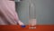 Close-up of male hands pouring sparkling mineral water into transparent glass