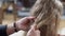 Close-up of male hands trying making pigtail on long curly child's hair. Unrecognizable Caucasian young father taking